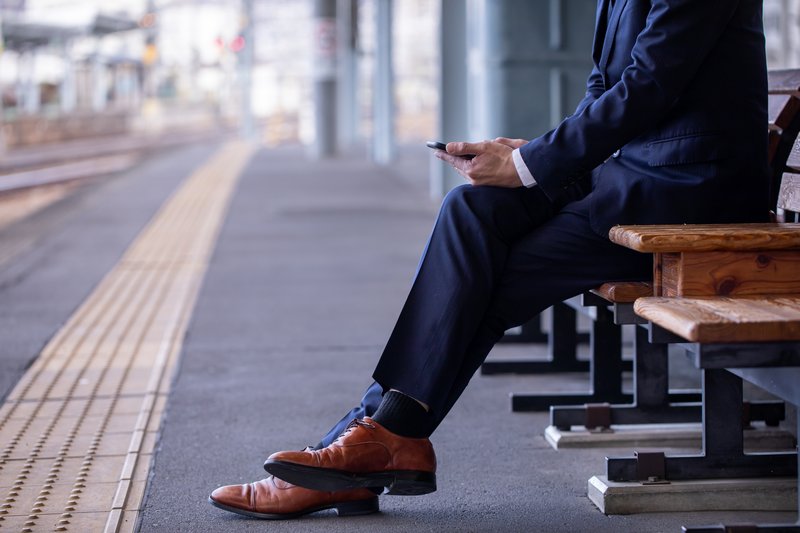 駅のホームで携帯電話を操作する男性 Train