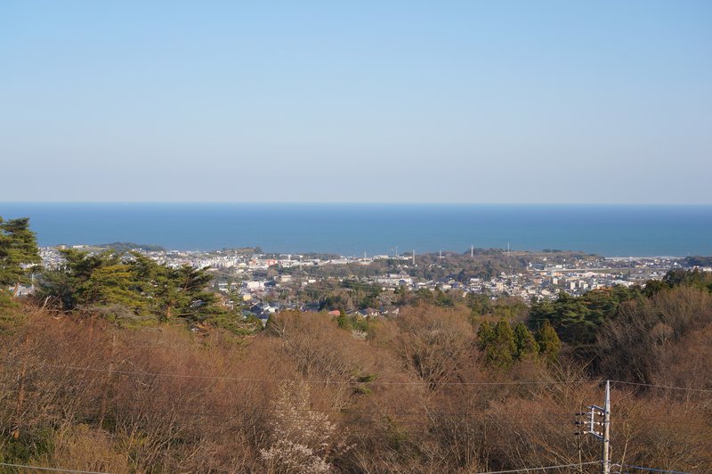 高台から見た海と住宅地の街並み